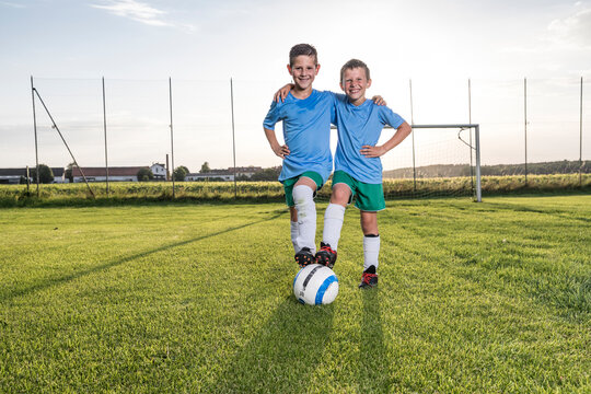 Smiling young football players embracing on football ground