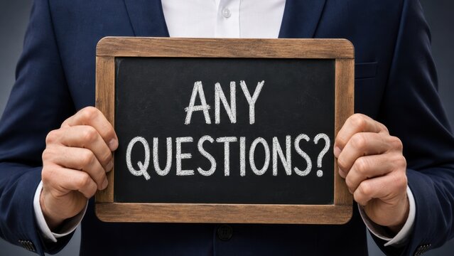 Opening the floor for discussion: Corporate speaker holding a vintage chalkboard with "Any Questions?" text. Concept of interactive Q&A sessions, audience feedback, and professional presentations