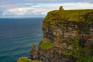 Long range view of a castle turret on a cliff above the ocean in ireland © Manuel