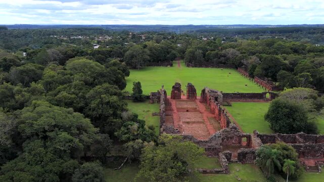 The San Ignacio Mini ruins lie amidst a vast green landscape in Misiones Province, Argentina. Ideal for historical documentaries or travel features.