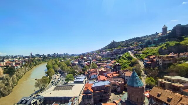Video looking down from an ascending ropeway cabin over the Mtkvari River valley in Georgia.