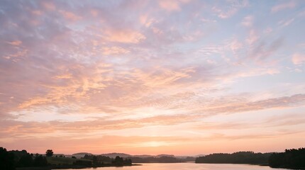Fototapeta premium Pastel sunset clouds over tranquil lake and rolling hills