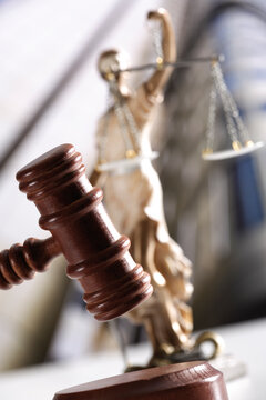 Justitia figurine behind gavel, tilt view