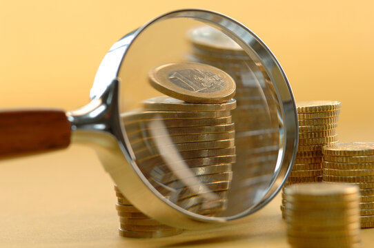 Euro coins under magnifying glass, close-up