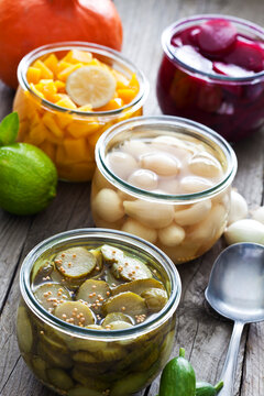 Preserving jars of different pickled vegetables