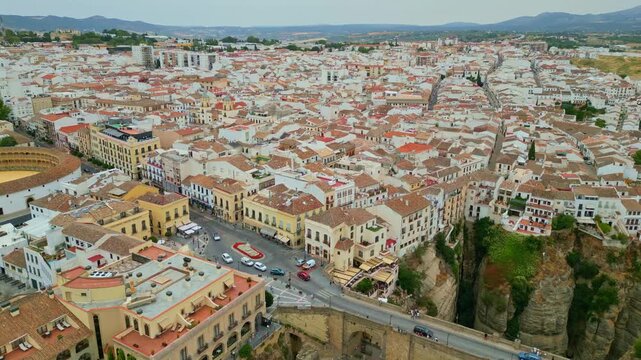 Spectacular view of the historic Puente Nuevo stone bridge in Ronda, Andalusia. Iconic medieval architecture spanning across the deep El Tajo gorge with whitewashed cliffside houses in Spain.