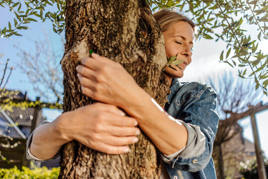 Woman in garden hugging a tree