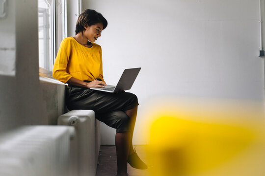 Woman sitting at the window using laptop