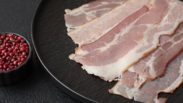 Raw fresh bacon slices with layers of meat or prosciutto with salt and spices. Raw bacon as a food background for your design