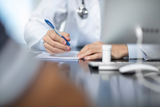 Doctor sitting at his desk taking notes