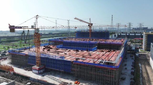 Large construction site with tower cranes and scaffolding framework