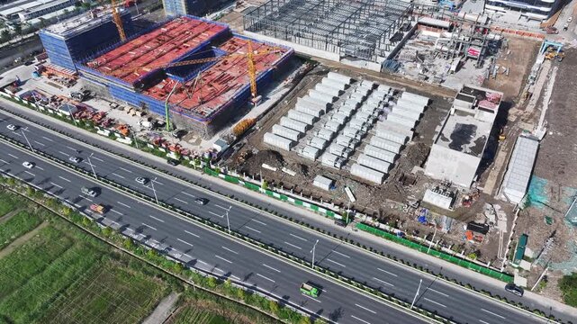 aerial view of a large construction site with road traffic and building framework