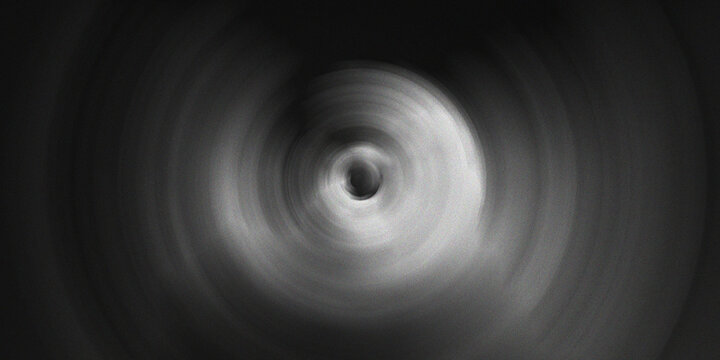Abstract circular tunnel vortex effect in black and white with high contrast radial motion blur creating deep infinite depth look.