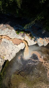 Epic cinematic tracking shot over majestic Kapas Biru canyon &ndash; Hidden tropical paradise waterfall with roaring cascade and morning sun rays, professional marketing video for travel tourism