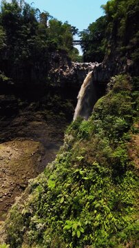 Cinematic aerial view of Kapas Biru waterfall in East Java &ndash; Breathtaking drone shot of the dramatic jungle canyon and majestic cascade during beautiful morning sunrise in Indonesia 4k