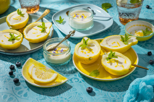 Delicious lemon posset dessert served in peel boats with mint and zest