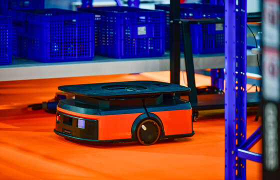 Autonomous mobile robot AMR navigating through modern smart warehouse floor.