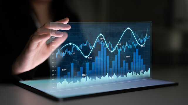 A person interacts with a transparent digital display showing stock market graphs and data visualizations, emphasizing trends and financial performance metrics. Scalp