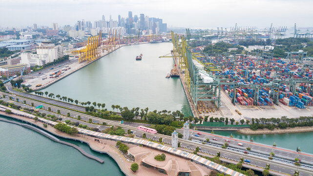 Aerial View of Busy Industrial Container Port with City Skyline Background