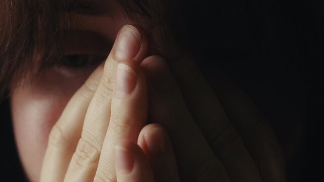 A close up of a tired and upset woman rubbing her face and eyes. She covers her face with her hands as she tries to relax and cope with stress. High quality 4k footage