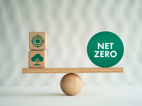 Net zero concept with wooden blocks and green earth icons on balance scale