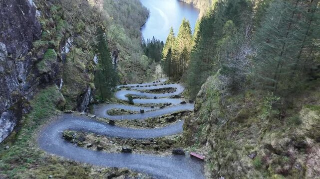 Kossdalen hairpin road at Hosanger on Osteroy Norway, with valley forest and fjord landscape reveal