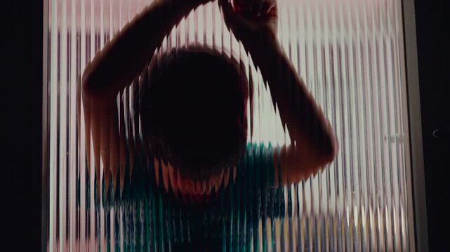 Child silhouette with arms raised against textured glass, themes of childhood isolation emotional distance trauma depression barriers and unseen internal struggles