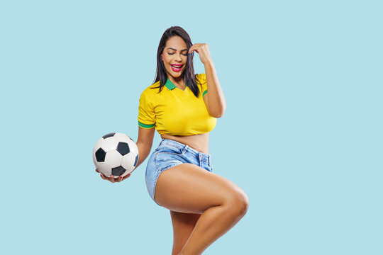 Beautiful young sporty Brazilian woman soccer fan dressed in sportswear. soccer fan on celebrating, isolated on free colorful background.