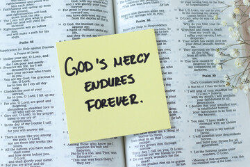Obraz premium God's mercy endures forever, inspirational quote with open holy bible book. Jesus Christ's grace, compassion, and forgiveness, biblical concept.