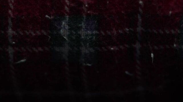 Dark red plaid wool fabric texture close up with vintage worn look