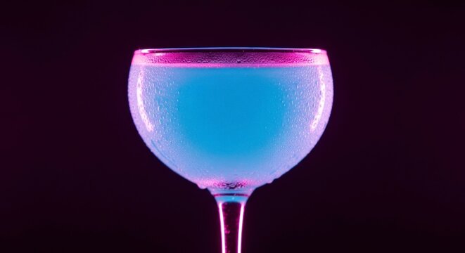 Elegante ta&ccedil;a de coquetel azul contra fundo preto com ilumina&ccedil;&atilde;o neon.