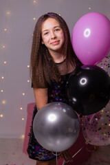 Naklejka premium teenage girl with purple birthday balloons and a large gift box