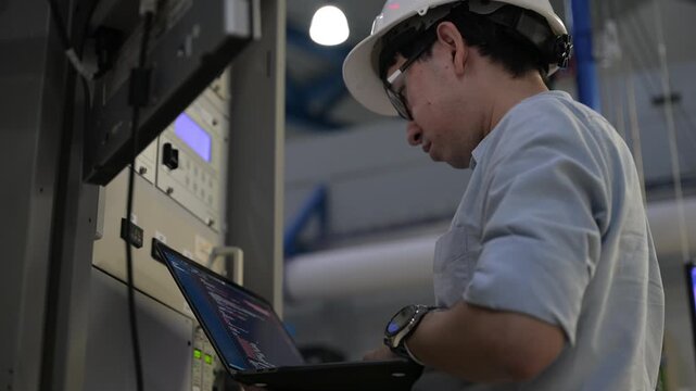 Electrical engineer male checking voltage at the Power Distribution Cabinet in the control room,preventive maintenance Yearly,inspecting power system and control panel in industrial factory