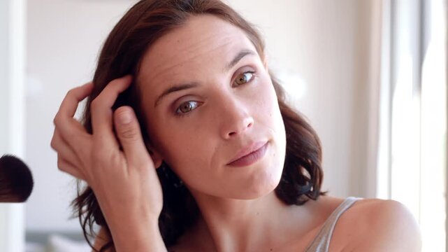 Woman, face and grooming with makeup brush in home for beauty cosmetics or foundation. Portrait, female person or POV with aesthetic tool, blush or blending for cosmetology or makeover in house