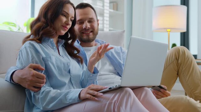 Happy smiling Caucasian family couple shopping with laptop and credit card buying online with easy banking service smile hugging cuddling at home man with woman buy with computer internet payment hug