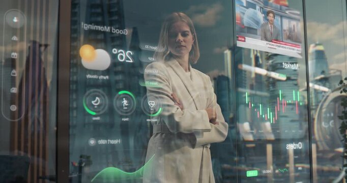 Business Woman Stands by Interactive Holographic Window, Making Gesture to Optimise Displaying Health Metrics, Weather, Stock Market Data and News, With Futuristic City Reflected Outside.