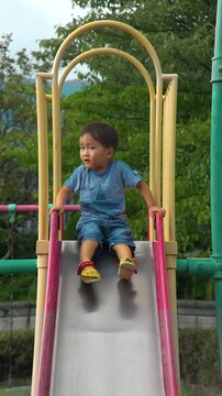 滑り台をする男の幼稚園児