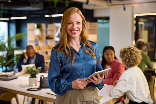 Happy young businesswoman looking at camera