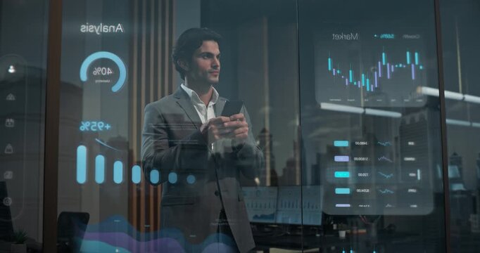 Businessman Stands Inside Contemporary Office Using Smartphone Application by Reflective Glass Window Showing Augmented Marketing Analysis, Financial Graphs, Trading Metrics, Fintech Intelligence Data