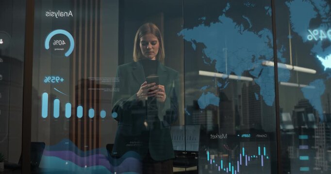 Female Professional Stands Inside Modern Office Tapping Smartphone Beside Reflective Window Projecting Holographic World Map, Kpi Bar Graphs, Marketing Metrics and Live Business Intelligence Dashboard
