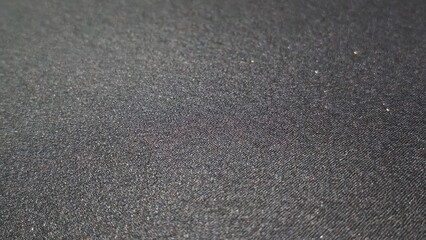 Fototapeta premium Dark asphalt texture with rough granular surface and subtle lighting. Urban background suitable for road, construction, industrial, and abstract texture design themes.