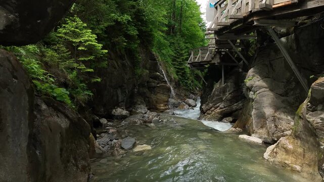 Austria dynamic drone flight above waterfall and narrow Sigmund Thun Klamm gorge near Kaprun. Atmospheric aerial footage of alpine canyon and powerful mountain river in cinematic 4K.