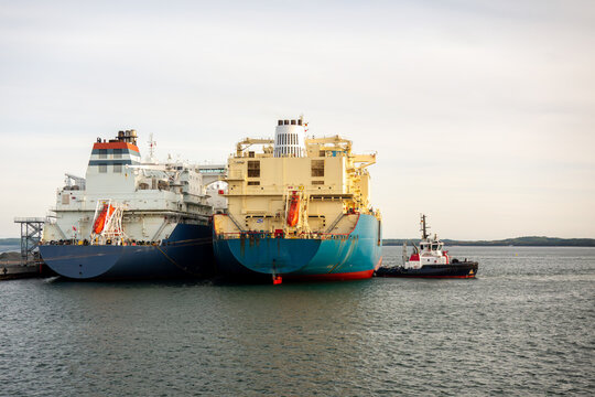 LNG Tanker Ship-to-Ship Transfer Operation at Industrial Port with Tugboat Assistance at Dusk