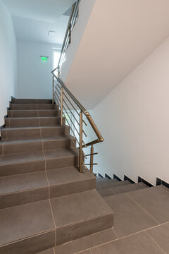 Modern stair case between floors. Stairs with metallic rail in modern building