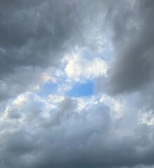 Fototapeta premium Blue sky opening through dramatic dark clouds