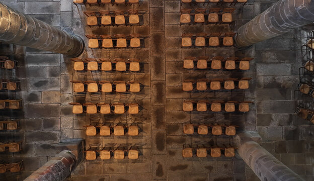 Aerial view of the interior of Eglise Saint-Melaine de Morlaix featuring rows of wooden chairs on a stone floor between massive stone pillars in Morlaix, Bretagne, France.