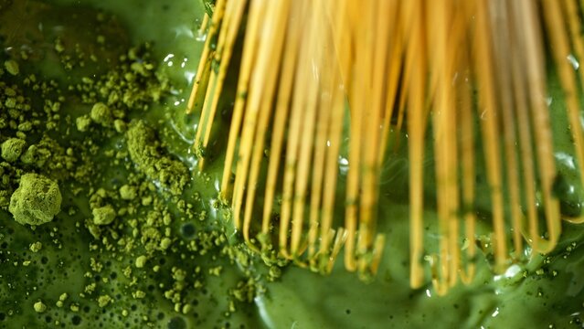 Bamboo Whisk Mixing Matcha Tea in Macro