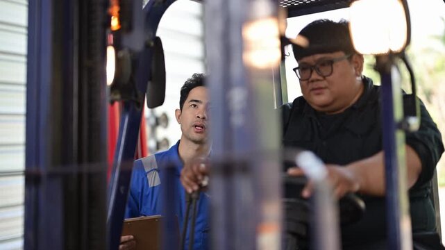 Warehouse supervisor training new forklift driver