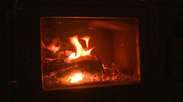 暖炉の中で薪が炎を揺らめかして燃える
