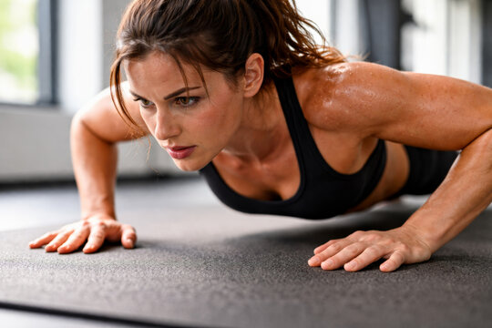Young woman doing push-ups at the gym for fitness